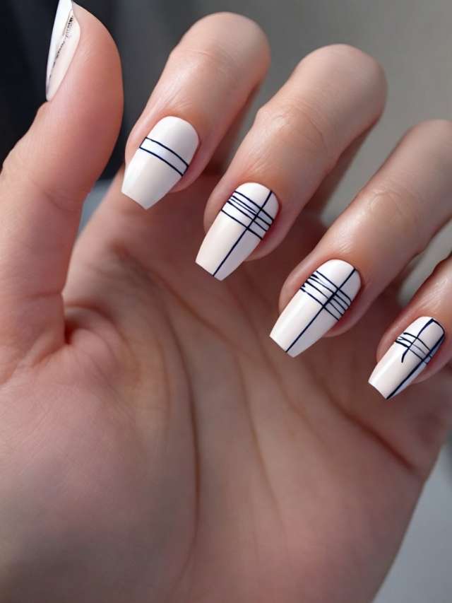 White nails with delicate black line art, resembling abstract drawings.